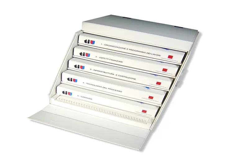 Coffret ASTRO rembordé de balacron blanc avec impression montage intérieure comprenant 5 compartiments pour classeurs dos de 35mm et 45mm avec mécanique et une grande cale pour insérer une plaquette de livre format 420mm par 300mm reliée par un wire-o fermeture par abattants avec mors et tourniquets nickelé et 2 poignées en plastique blanche