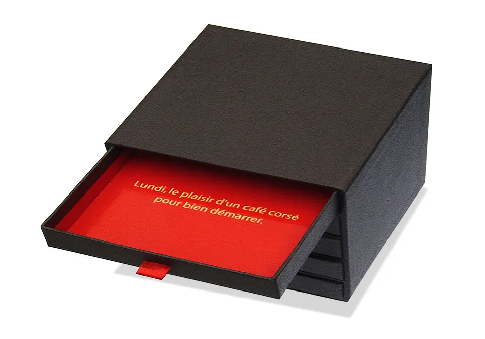 Coffret Nestlé à tiroirs contrecollé rembordé d’un papier de création – intérieur contrecollé de papier offset rouge.