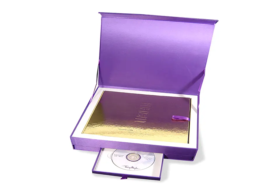 Coffret Thierry Mugler avec couvercle à rabat aimanté contrecollé de toile satin – impression à chaud ton sur ton – grille de calage « trottoir » en microcannelure contrecollée de papier pelliculé – tiroir avec cale en carton gris contrecollé de papier brillant pelliculé – rubans extracteur et limiteurs d’ouverture d’angle – Classeur contrecollé rembordé de papier or avec marquage or et intercalaires en polypropylène violet sérigraphiés – découpe d’onglets.