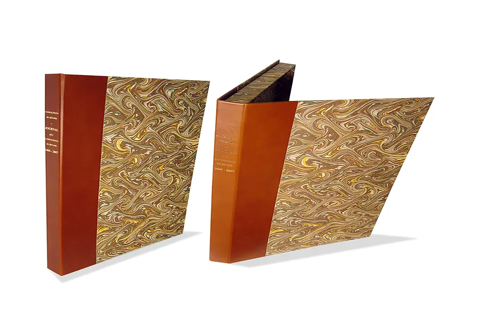Editis - Coffret-livre contrecollé rembordé de papier marbré – dos en cuir vachette doré à chaud.